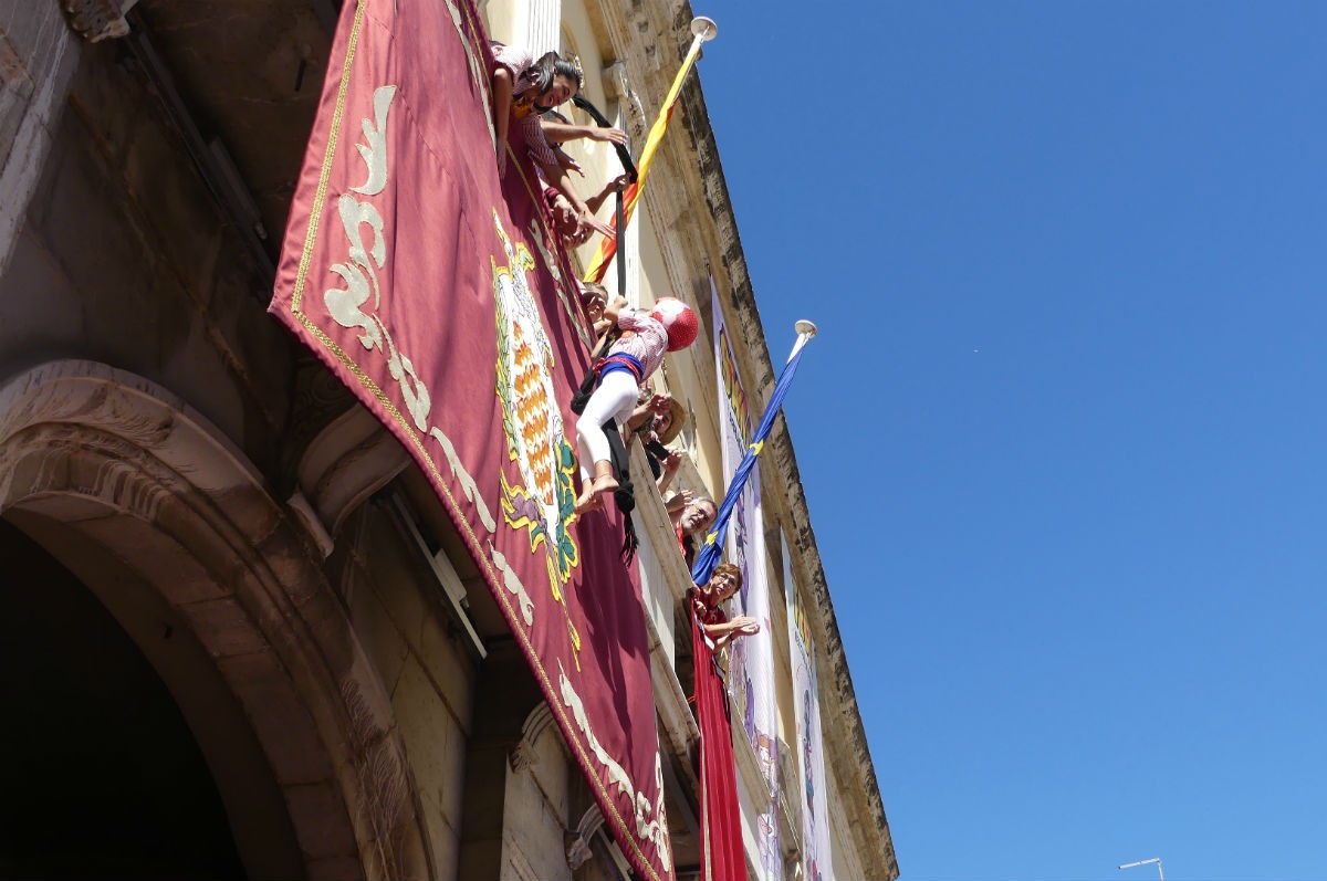 L'enxaneta del pilar caminant dels Xiquets de Tarragona pujant pel balcó de l'Ajuntament. 