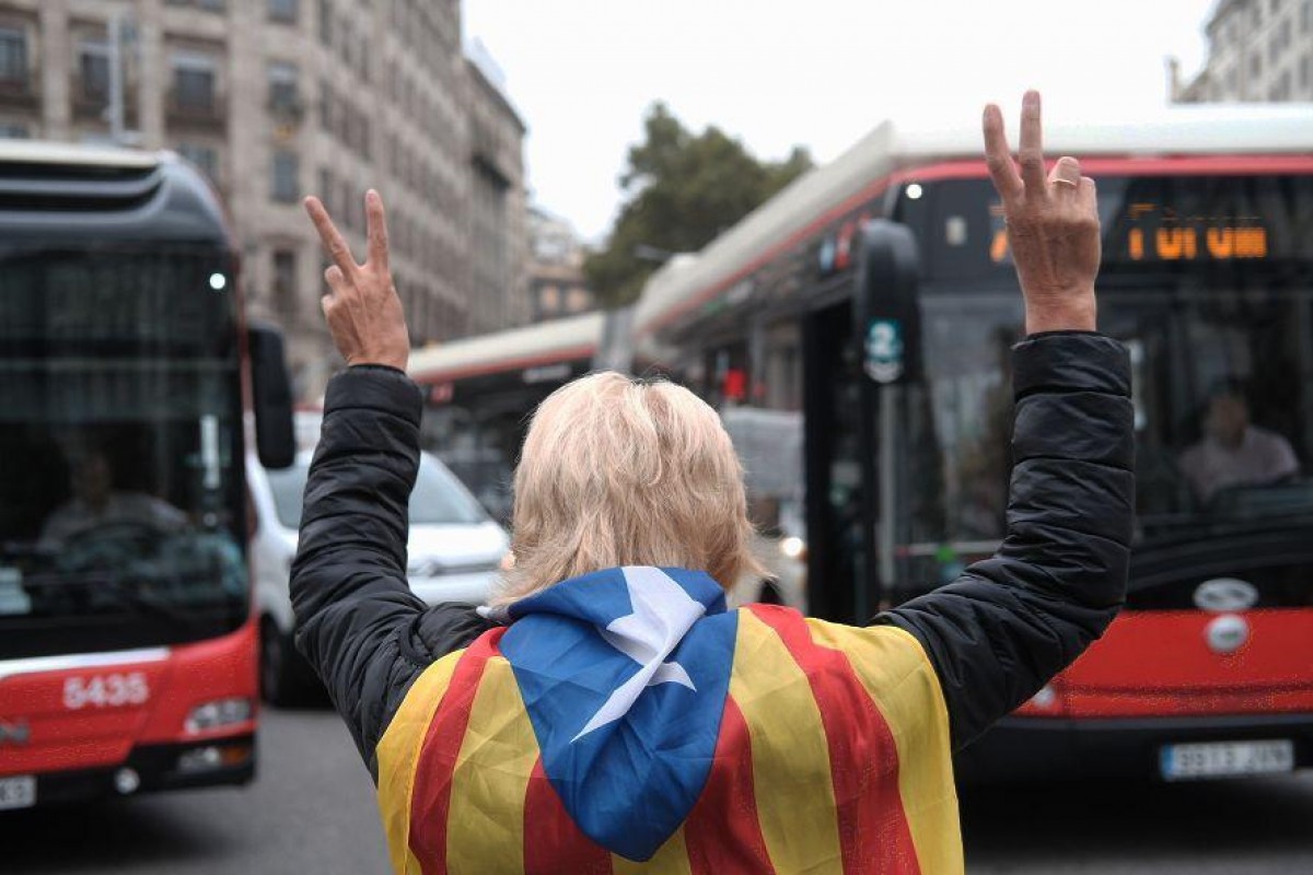 Una dona protesta davant uns autobusos de Barcelona