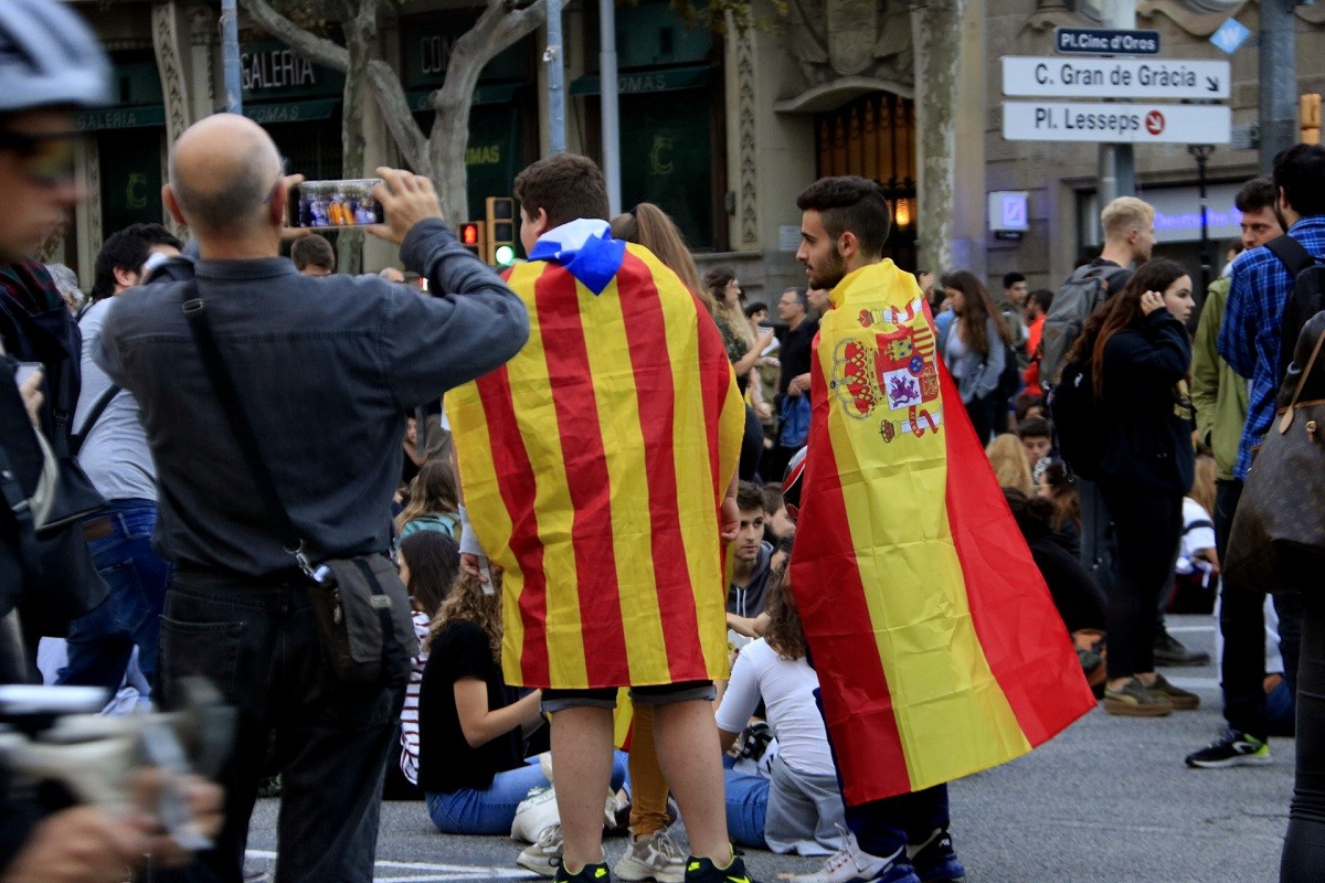 Dos nois llueixen banderes independentistes i espanyoles.