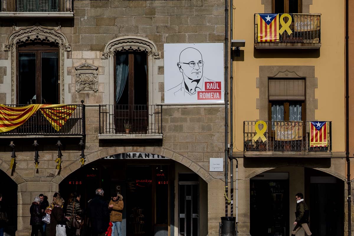 Pancarta amb el retrat de Raül Romeva penjada en una façana de la plaça Major de Vic