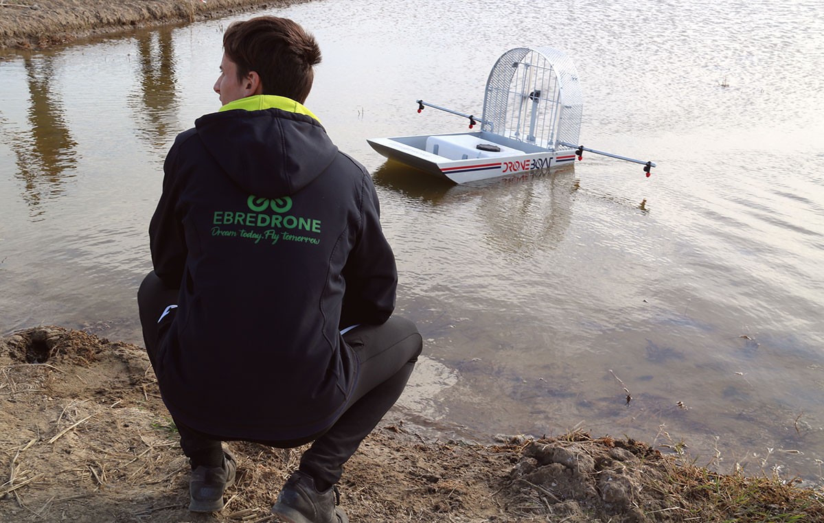 Un dels tècnics d'Ebredrone posant en marxa el prototip Droneboard en una parcel·la de cultiu d'arròs inundada a Amposta.