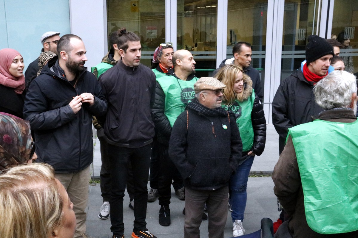 Berni Sorinas i Marc Garcés -de fosc a l'esquerra- envoltats de membres de la PAHC, a la sortida del judici