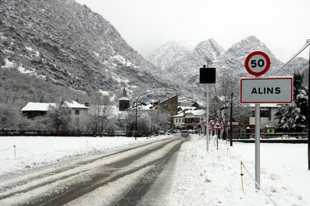 Panoràmica de l'entrada al poble d'Alins amb la carretera plena de neu