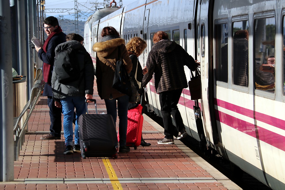 Usuaris d'un Talgo arribant i pujant al tren a l'estació de l'Aldea-Tortosa-Amposta. 