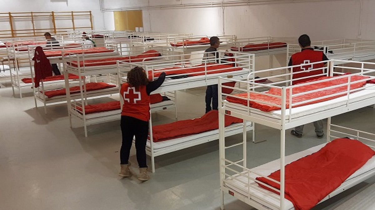 Voluntaris de la Creu Roja habiliten l'alberg d'emergència de l'Escola França.