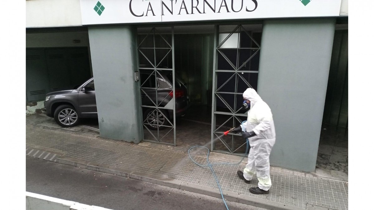 Un operari de l'Ajuntament de Terrassa desinfecta l'entrada de la residència Ca n'Arnaus, al centre de Terrassa.