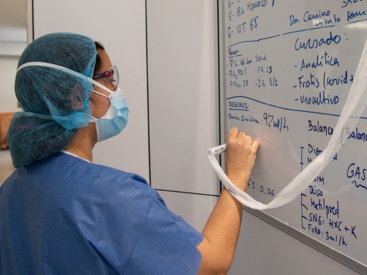 Una professional sanitària del Clínic pren notes en una pissarra