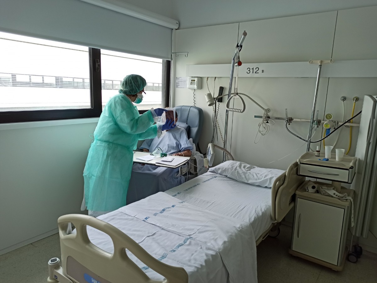 Un treballador de l'Hospital de Mollet, ajudant un pacient en una videotrucada