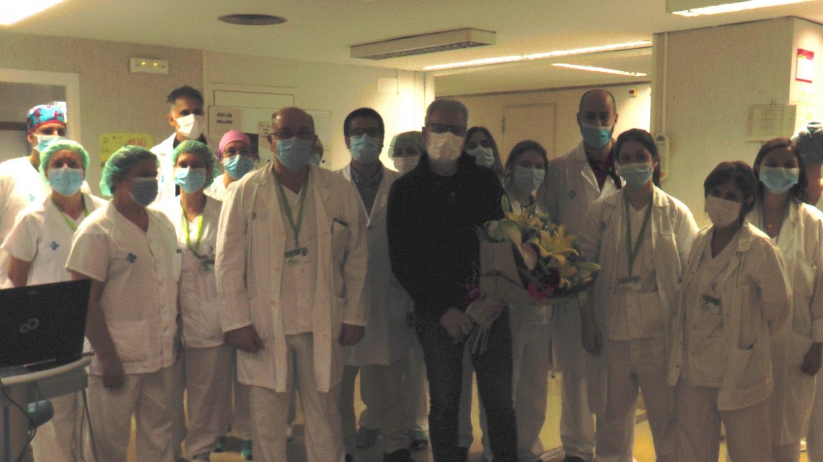Professsional sanitari obsequien el pacient donat d'alta amb un ram de flors.