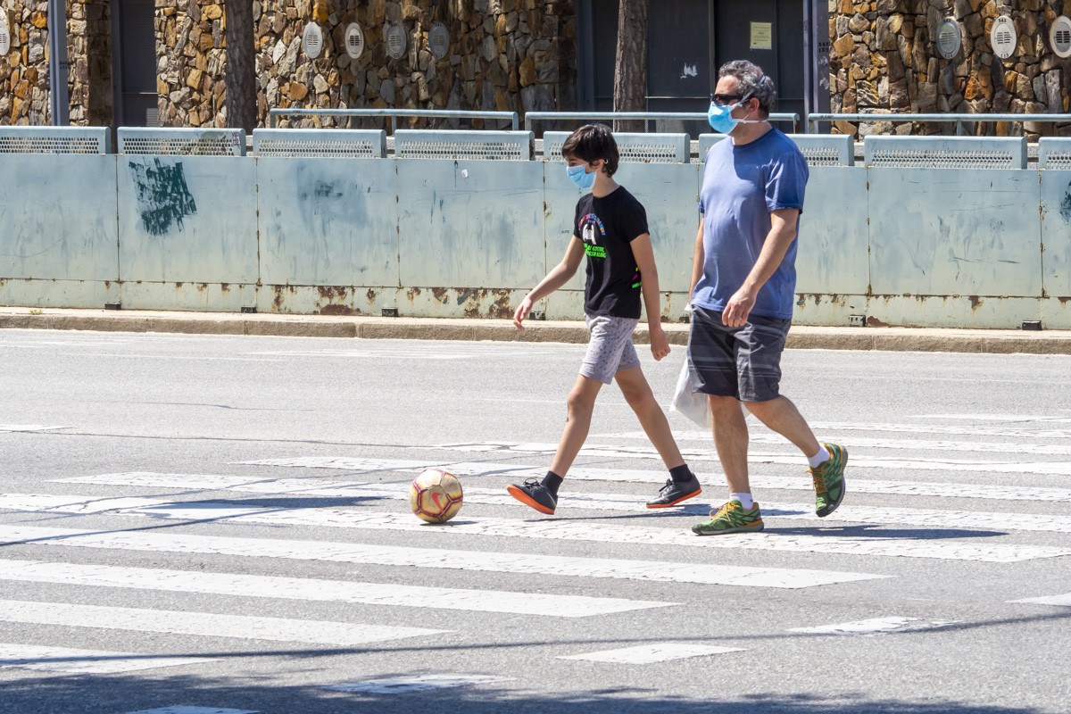 Un pare i el seu fill caminen per Sabadell en la primera fase de desconfinament. 