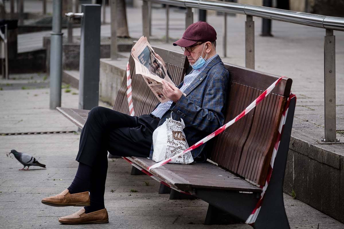 Un ciutadà llegint assegut en un banc
