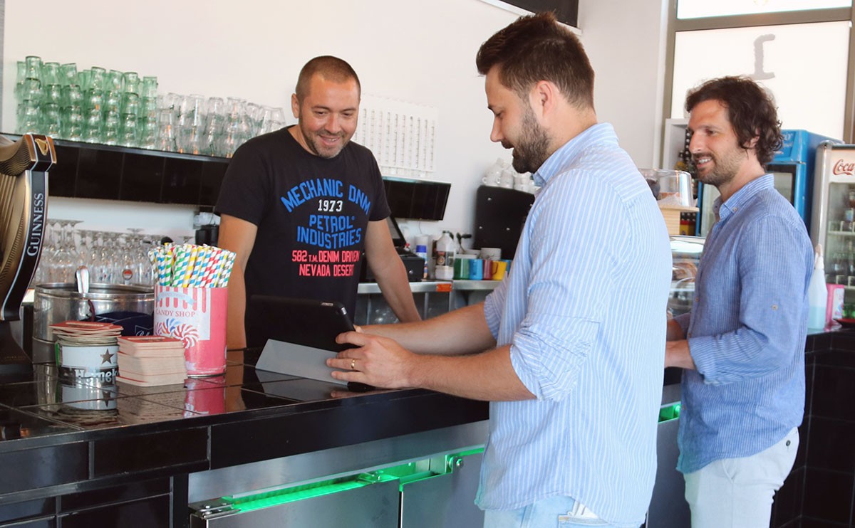 Els gerents de Teuporto, Xavier Marqués i Jordi Font, mostrant el projecte al responsable d'un bar de la Ràpita.