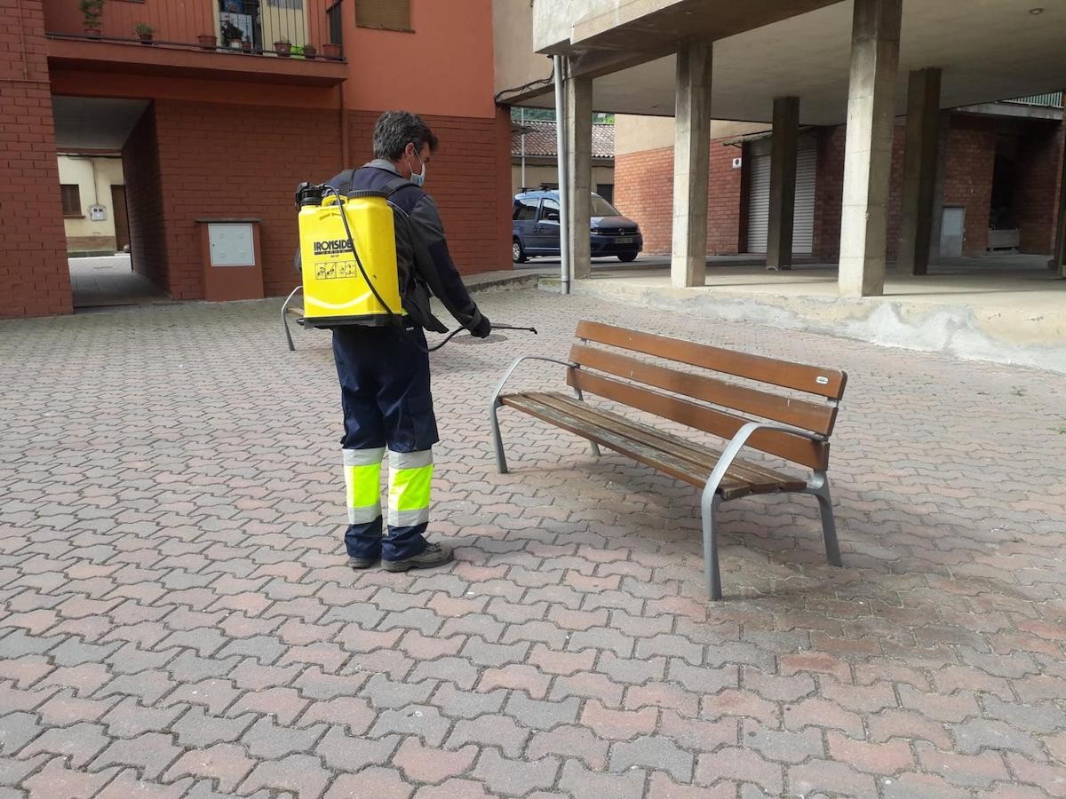 Un treballador municipal desinfecta un banc a Sant Joan les Fonts.