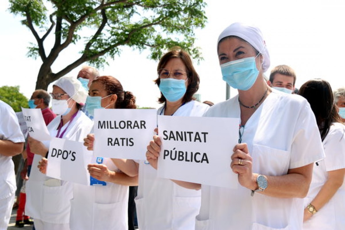 Professionals mostren cartells per una sanitat 100% pública 