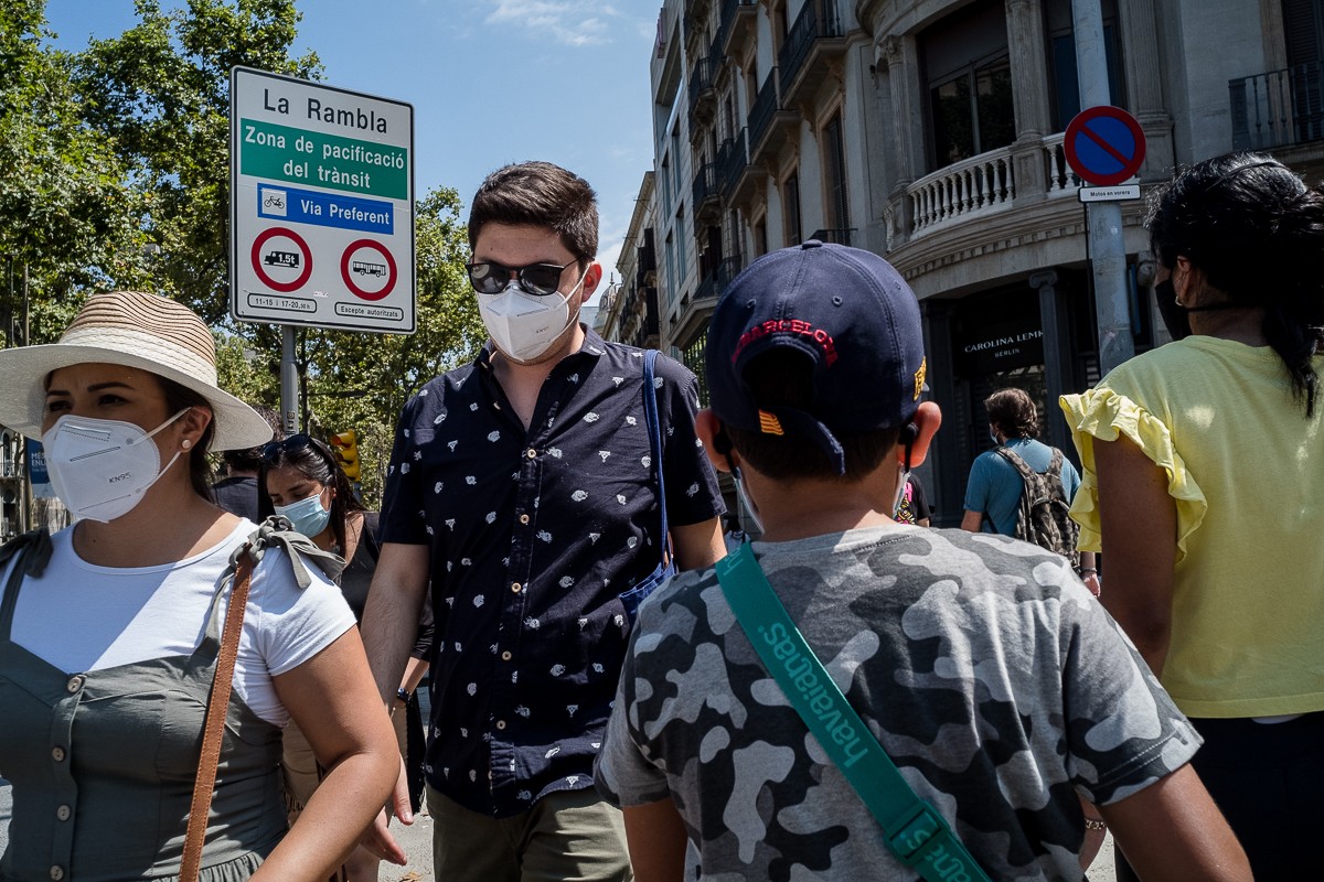 Gent amb mascareta al centre de Barcelona, aquest divendres, després que el Govern hagi recomenat quedar-se a casa als ciutadans de l'àrea metropolitana.