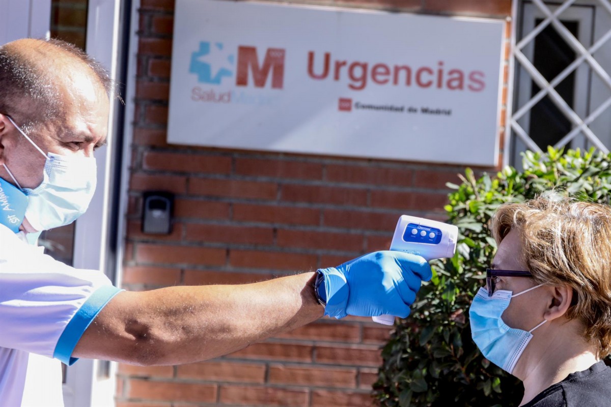 Un sanitari mira la temperatura a una dona en un hospital madrileny.