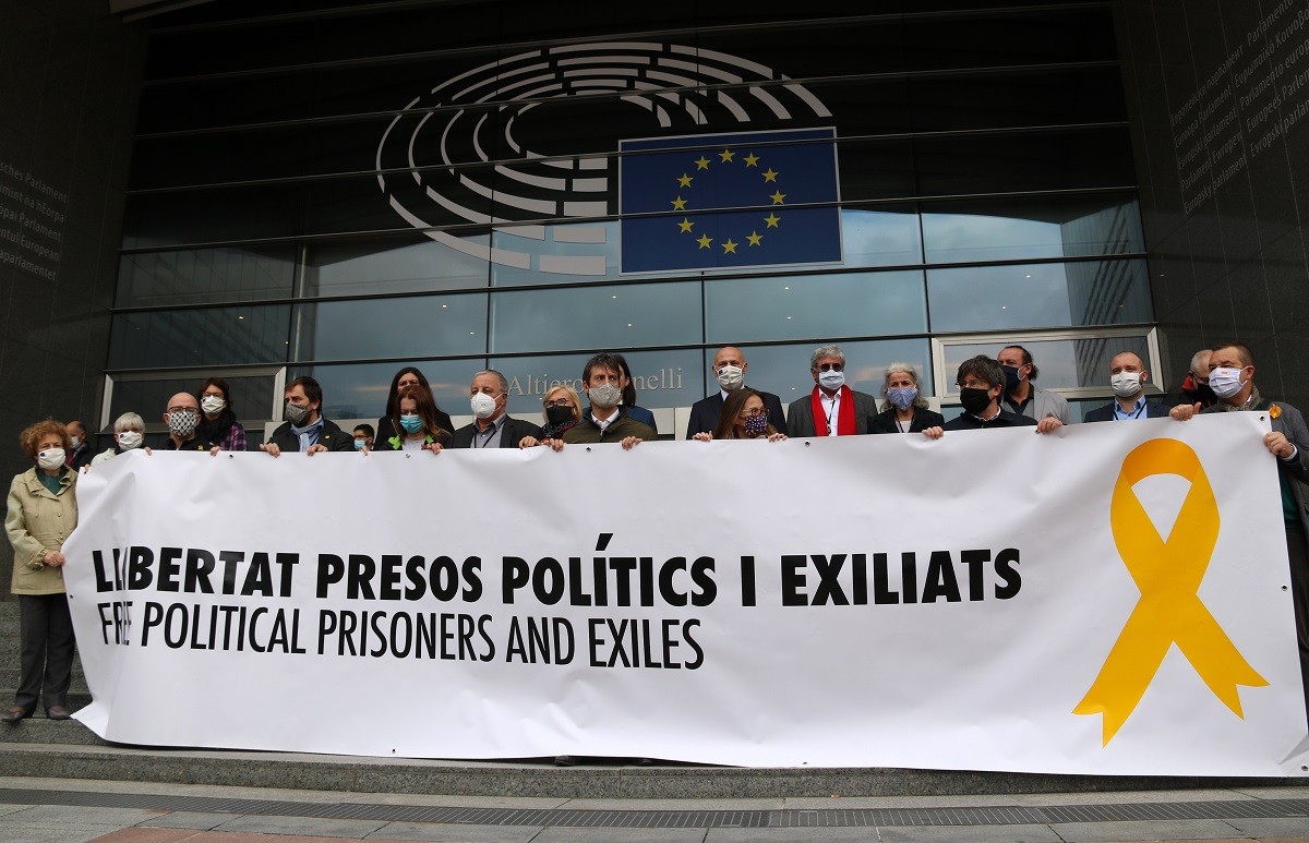 Una quinzena d’eurodiputats, inclòs Puigdemont, desplega la pancarta de Torra a l’Eurocambra.
