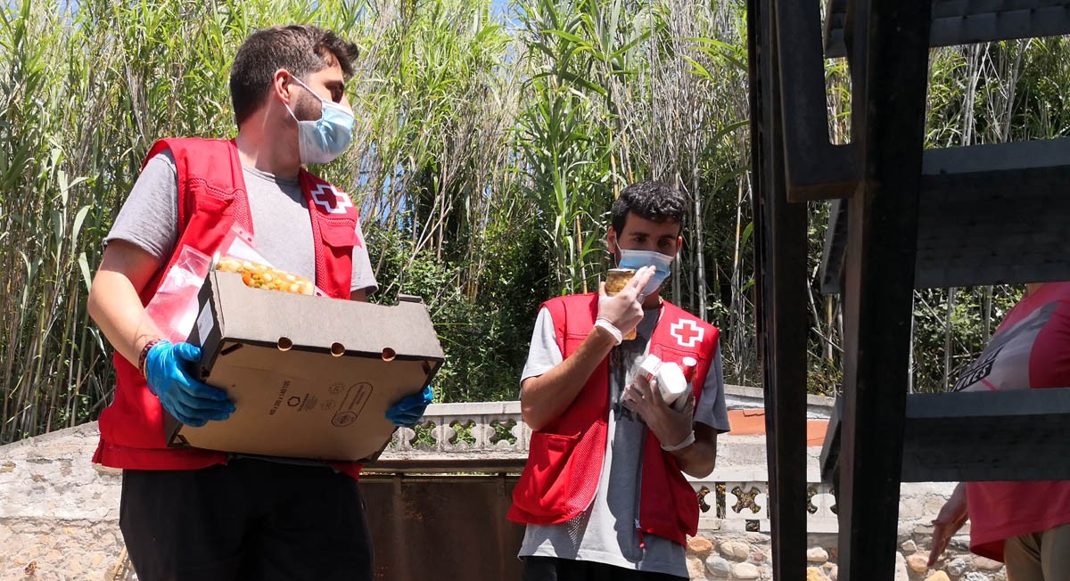 Dos voluntaris de Creu Roja repartint aliments durant l'estat d'alarma