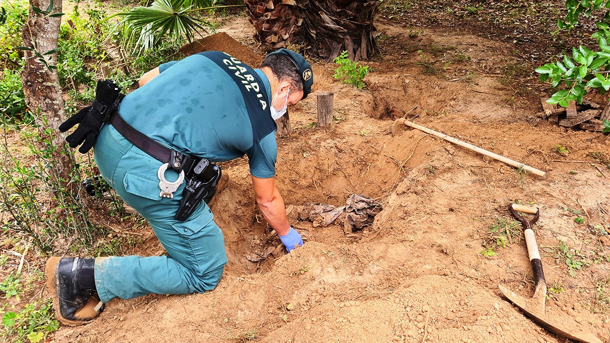 Un dels agents del seprona inspecciona restes de gossos morts