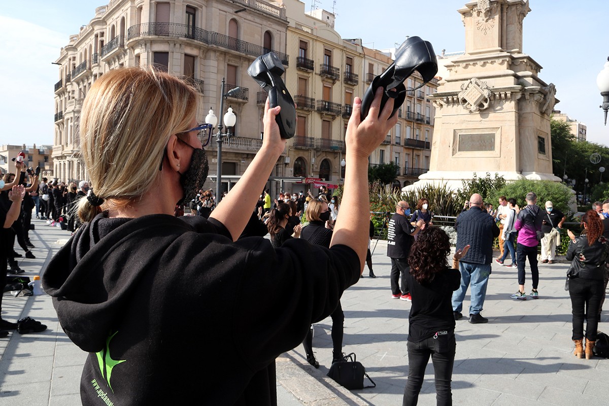 Una manifestant d'esquena aplaudint amb les sabates de ballar en la protesta per reclamar la reobertura de les escoles de dansa al Balcó del Mediterrani de Tarragona.