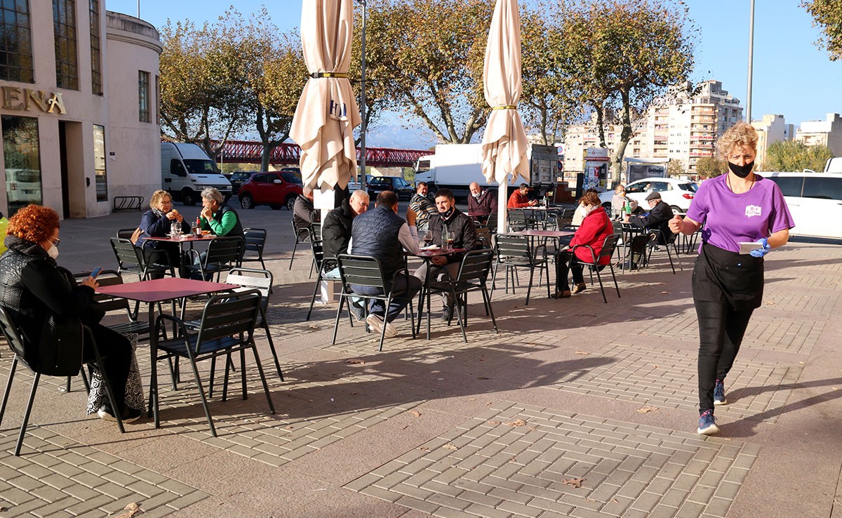 Terrassa del bar Ester de Tortosa amb la propietària servint als seus clients a l'exterior del Mercat Municipal.