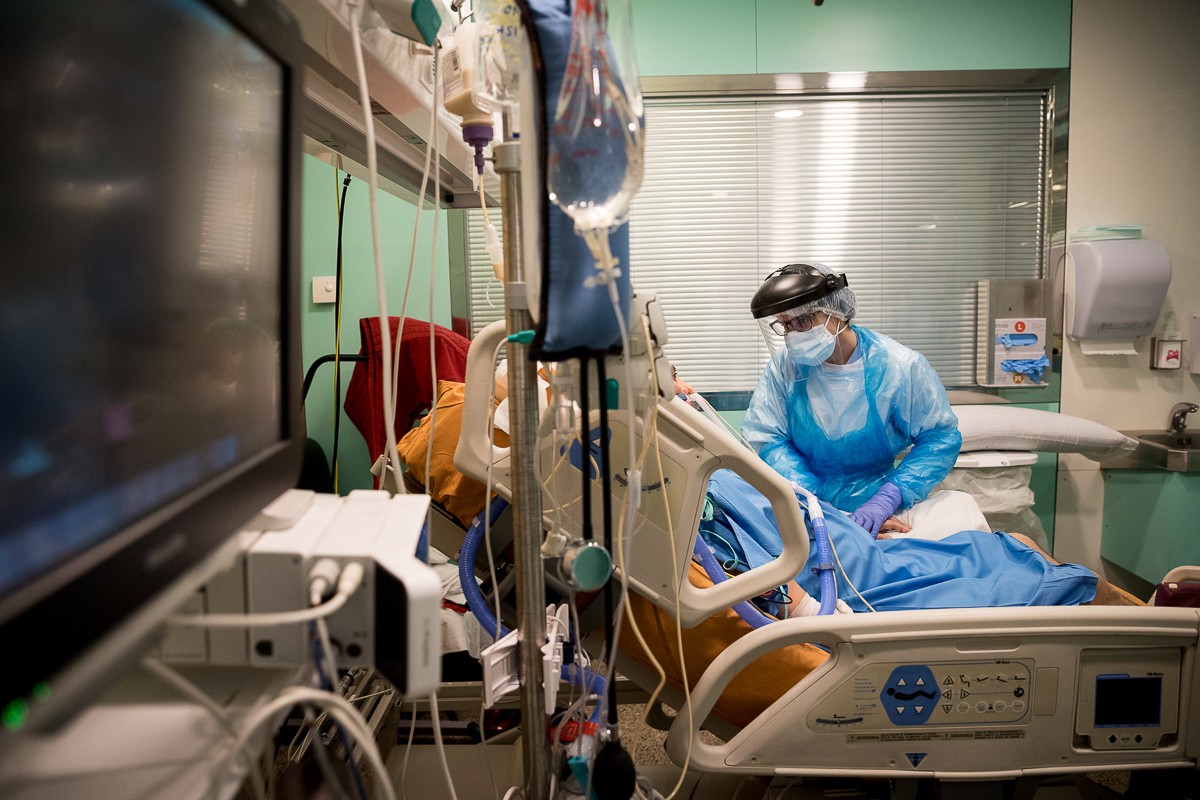 Una infermera atenent un pacient a la UCI de l'Hospital Universitari de Vic.