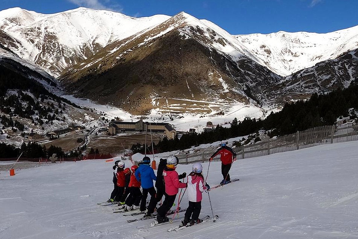 Un grup de joves esquiadors i el monitor a l'estació de Vall de Núria