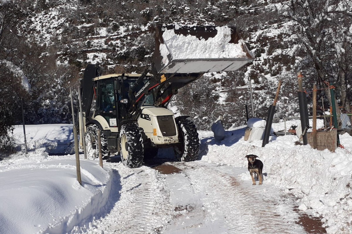 Una màquina retirant la neu del camí que dona accés al poble de Mencui