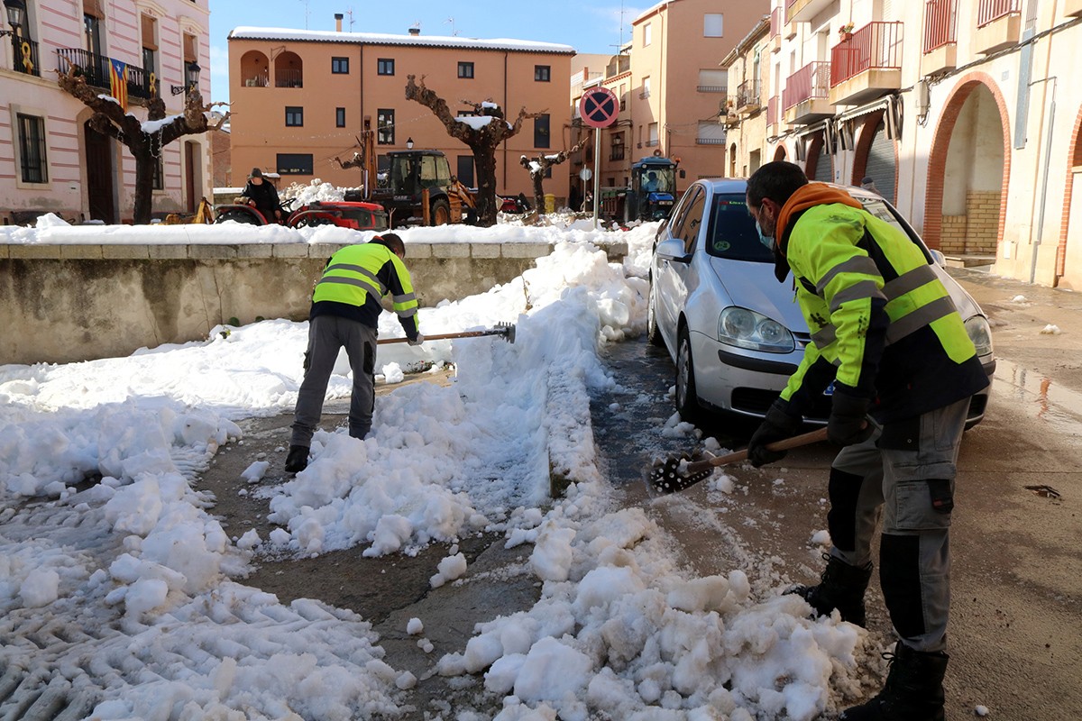 Veïns treballant per retirar neu a la plaça de les Arenes de Marçà, al Priorat.