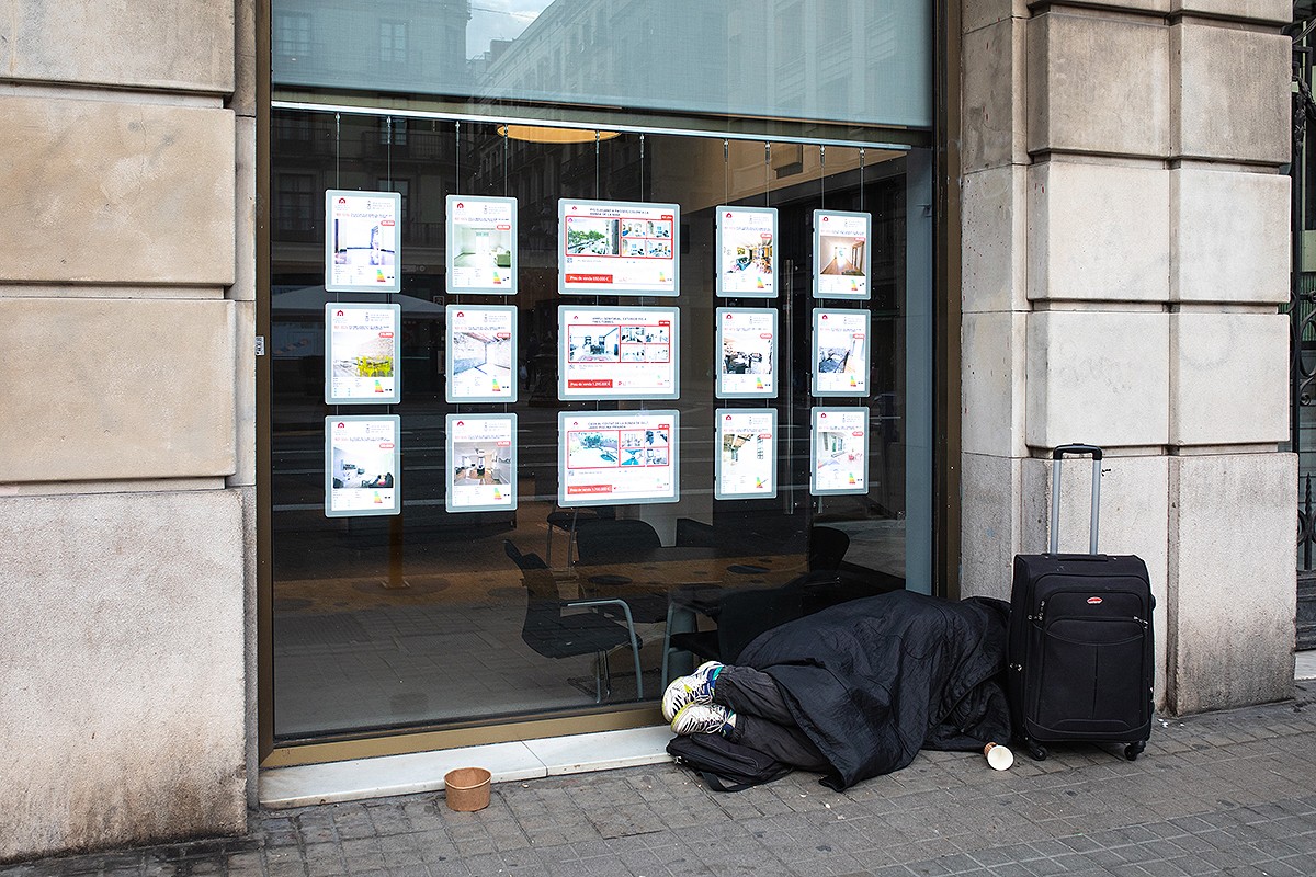 Una persona sense llar dormint al carrer.