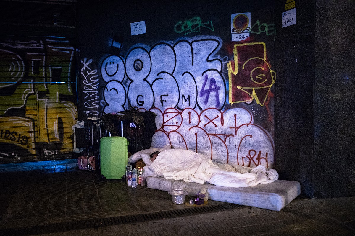 Imatge d'arxiu d'una persona sense llar dormint al carrer.