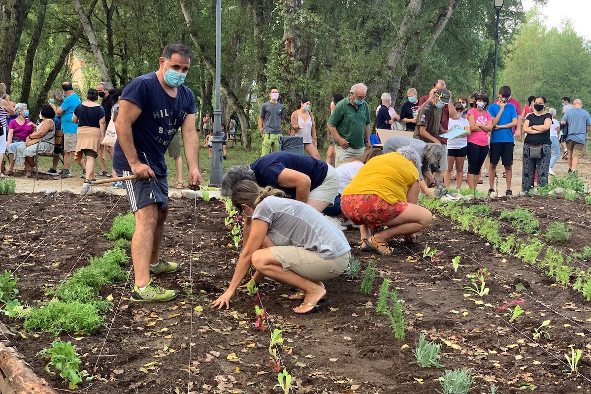 Gent plantant al jardí comestible de Senterada