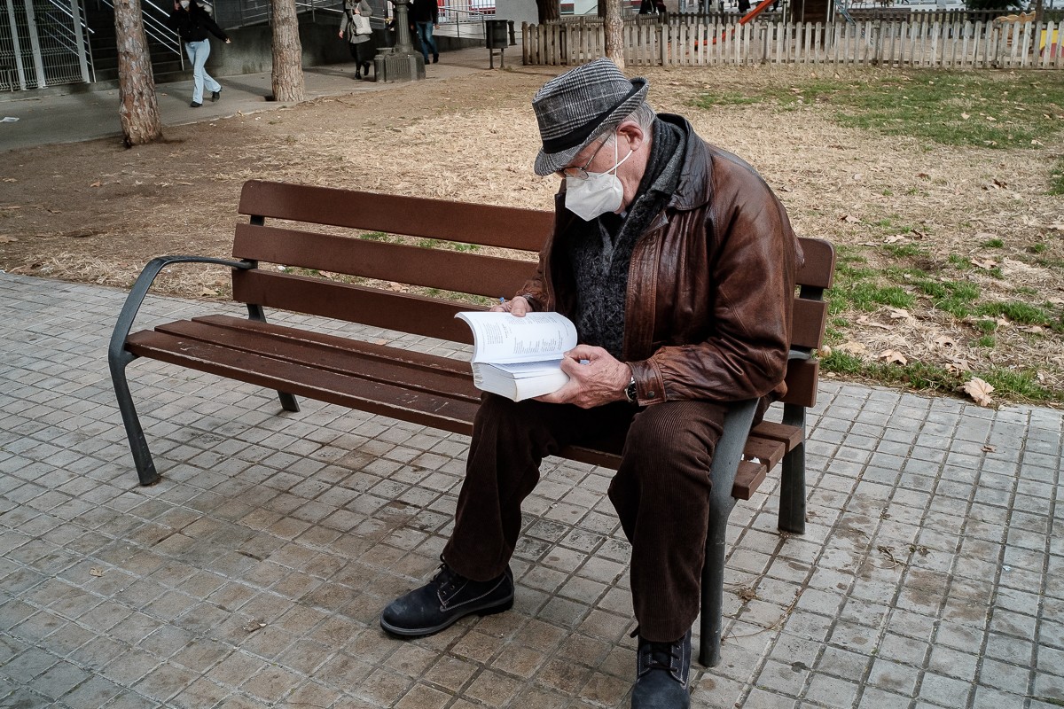 Un home llegint en un parc de Barcelona