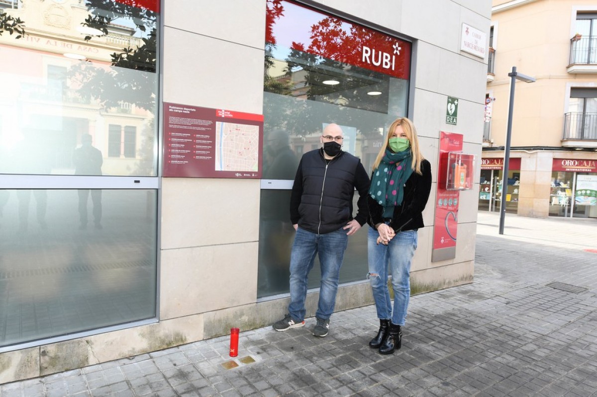 Pau Navarro i Ana María Martínez davant la placa informativa sobre les Stolpersteine