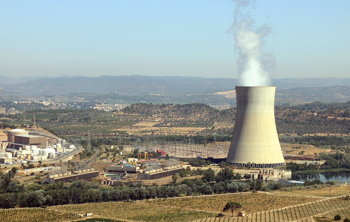 Central nuclear d'Ascó, amb la xemeneia fumejant a la dreta i els dos reactors a l'esquerra. 