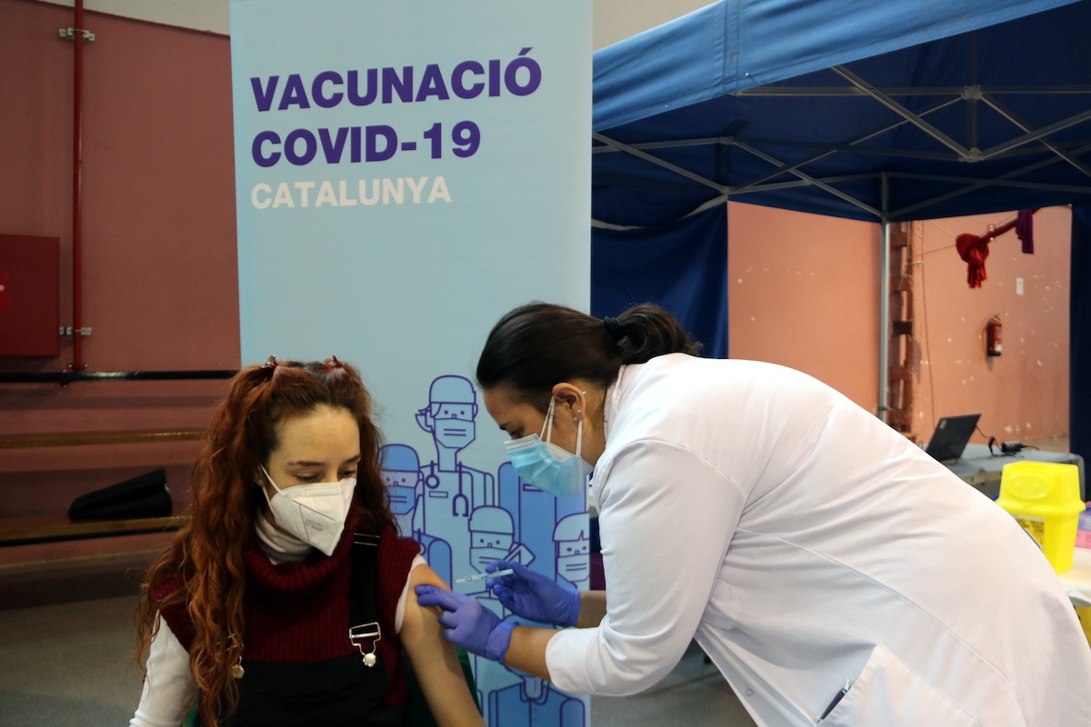 Una infermera posant una vacuna d'AstraZeneca a una dona a Tremp