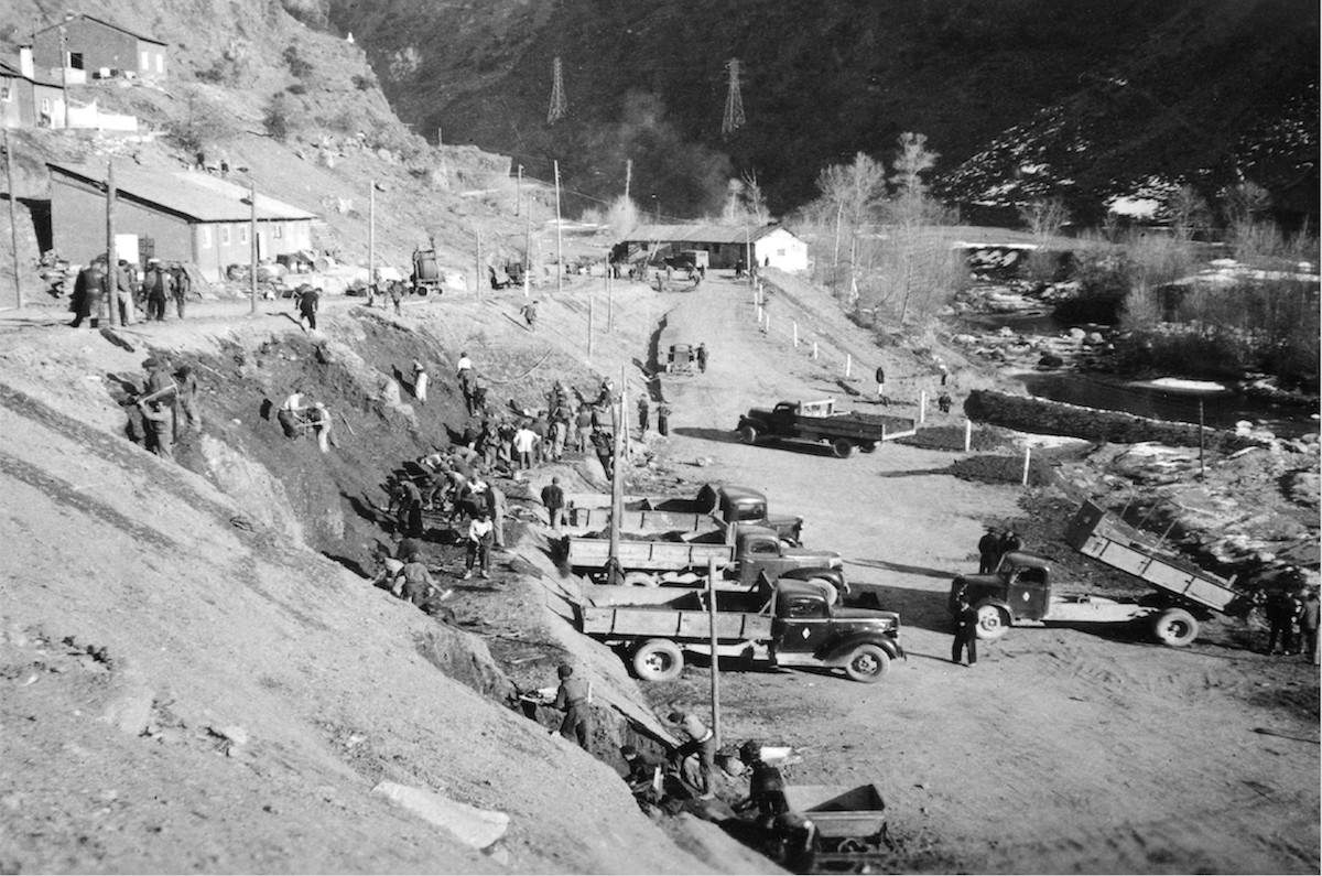 Treballadors i camions esplanant la central d'Escaló l’any 1950