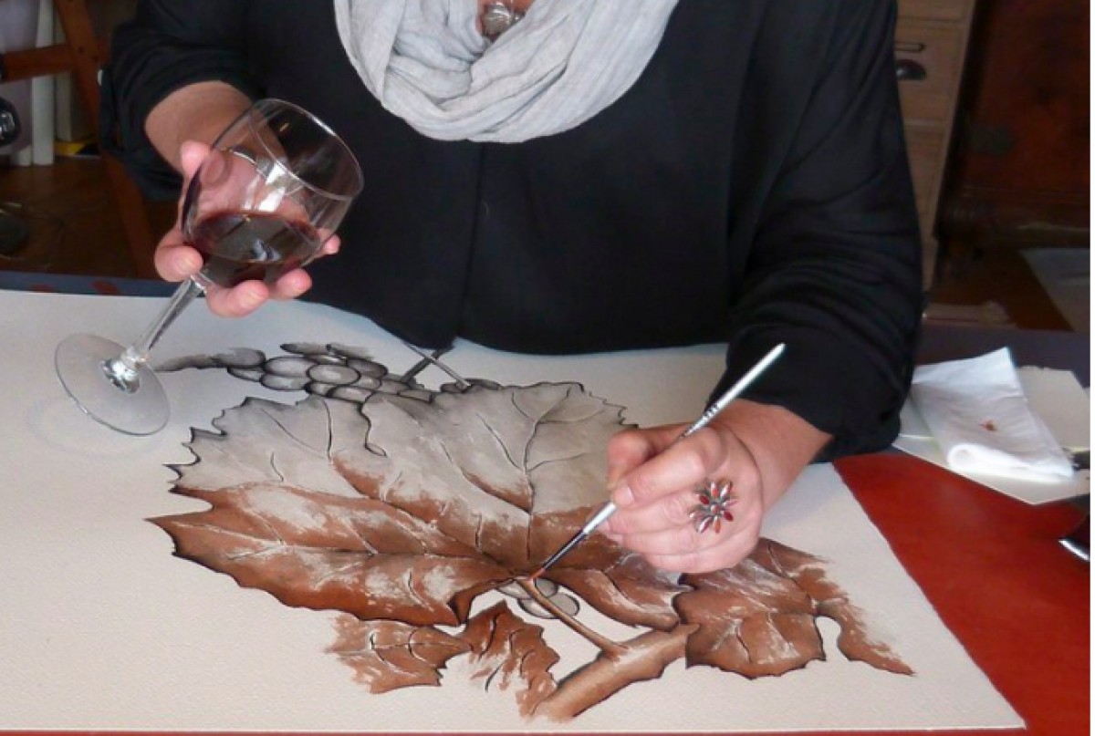 Una dona pinta un quadre amb vi
