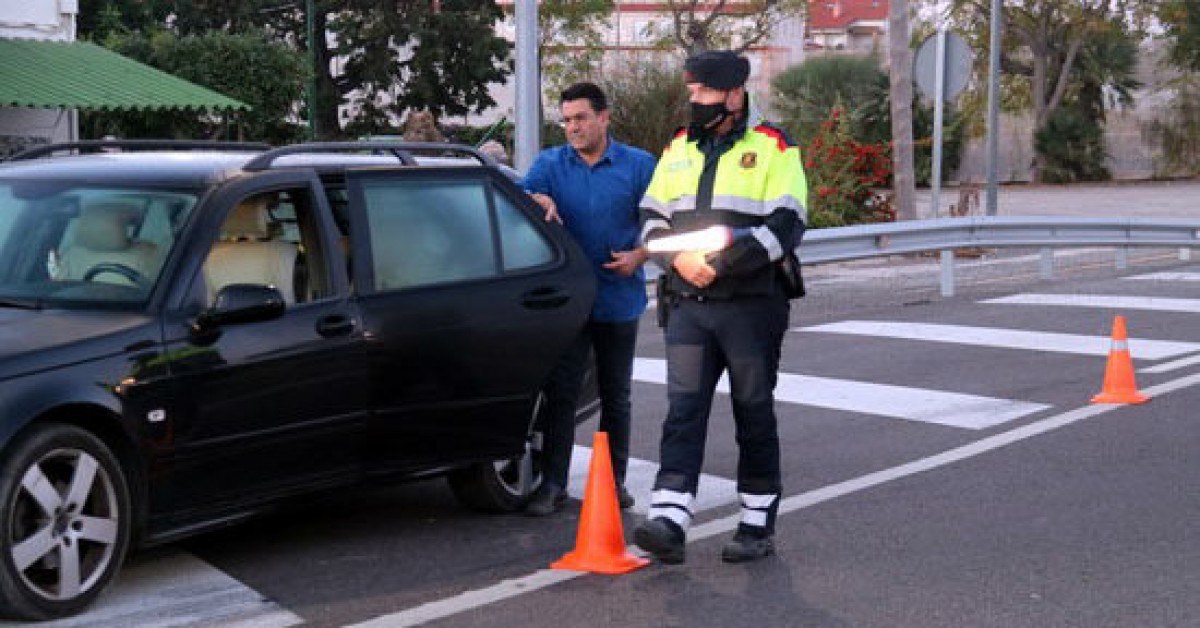 Pla general d'un conductor mostrant la documentació i els certificats de mobilitat a un agents dels Mossos en el control a la intersecció de l'N-340 a les Cases d'Alcanar, al límit amb el País Valencià