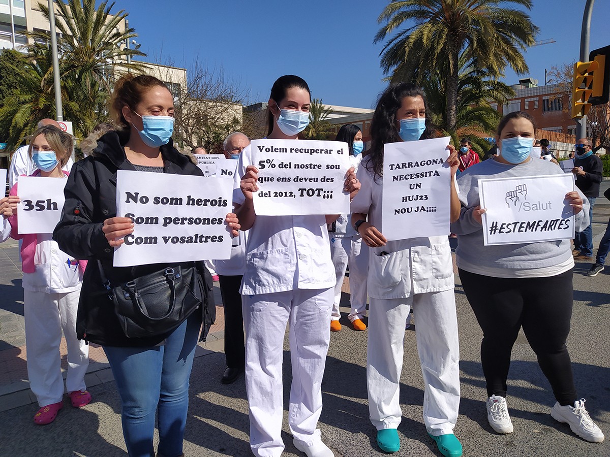 Quatre treballadores de la sanitat pública, amb cartells reivindicatius.