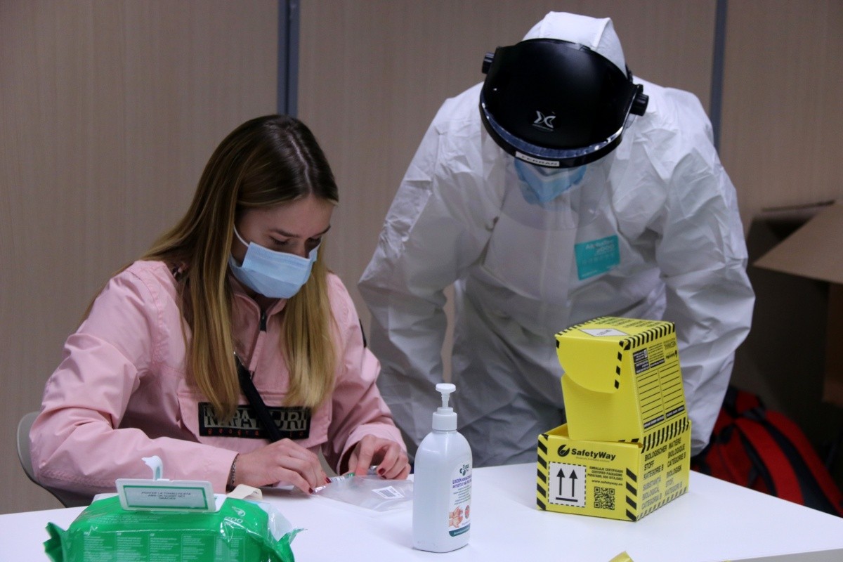 Una sanitària ajudant una estudiant a prendre la mostra per a la prova PCR al Campus Terres de l'Ebre de la URV, a Tortosa.