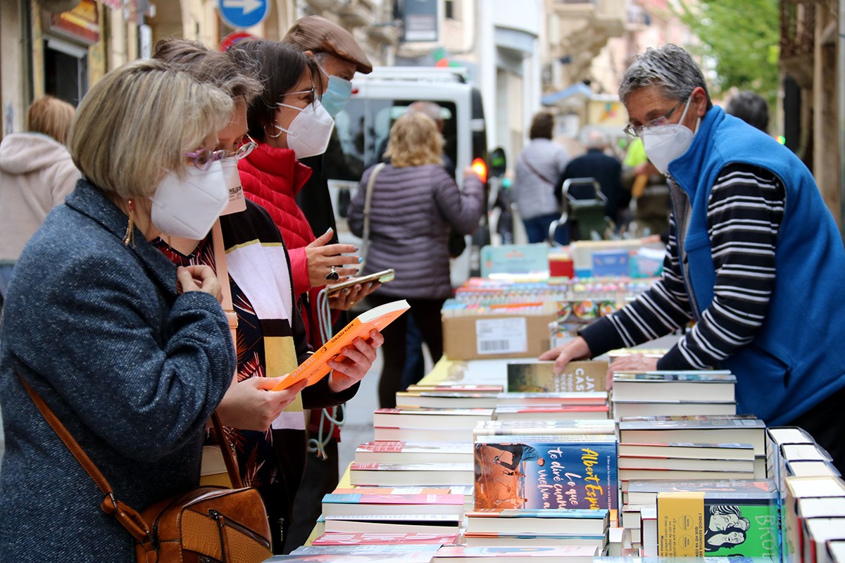 Persones mirant llibres en una de les parades de Sant Jordi a Valls.