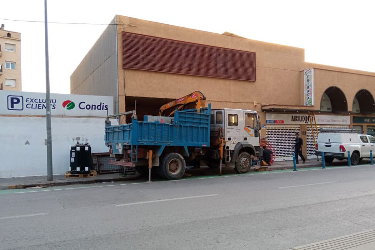 Un camió grua treballant per retirar el transformador avariat del soterrani del mercat