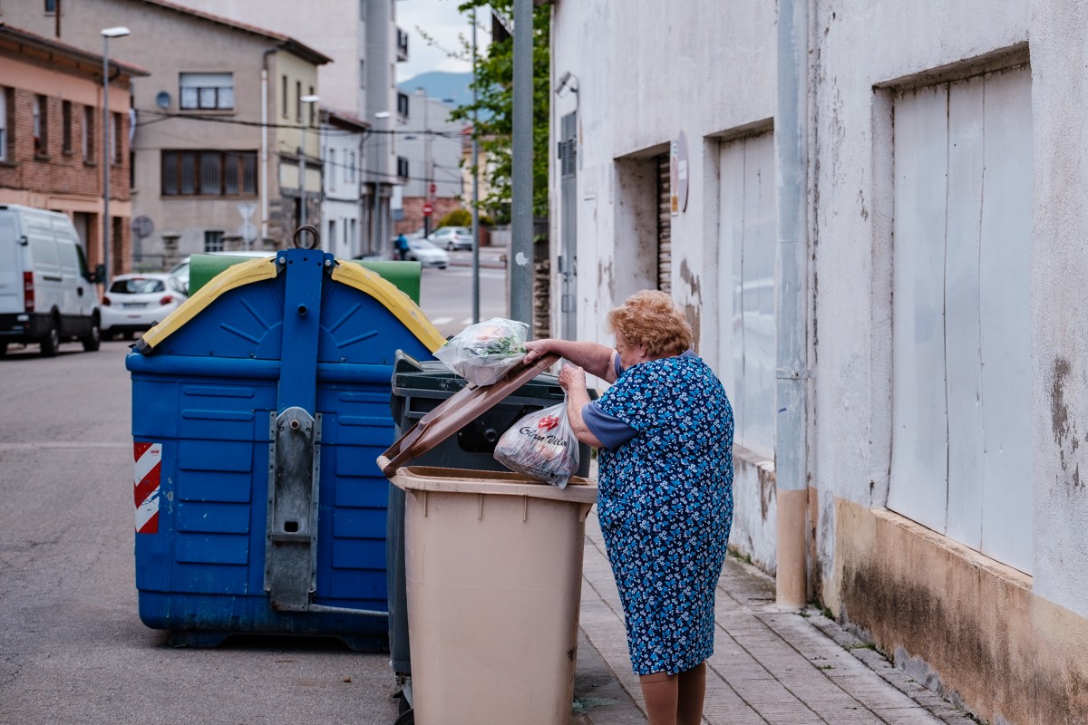Una senyora llença la fracció orgànica en un contenidor de Manlleu