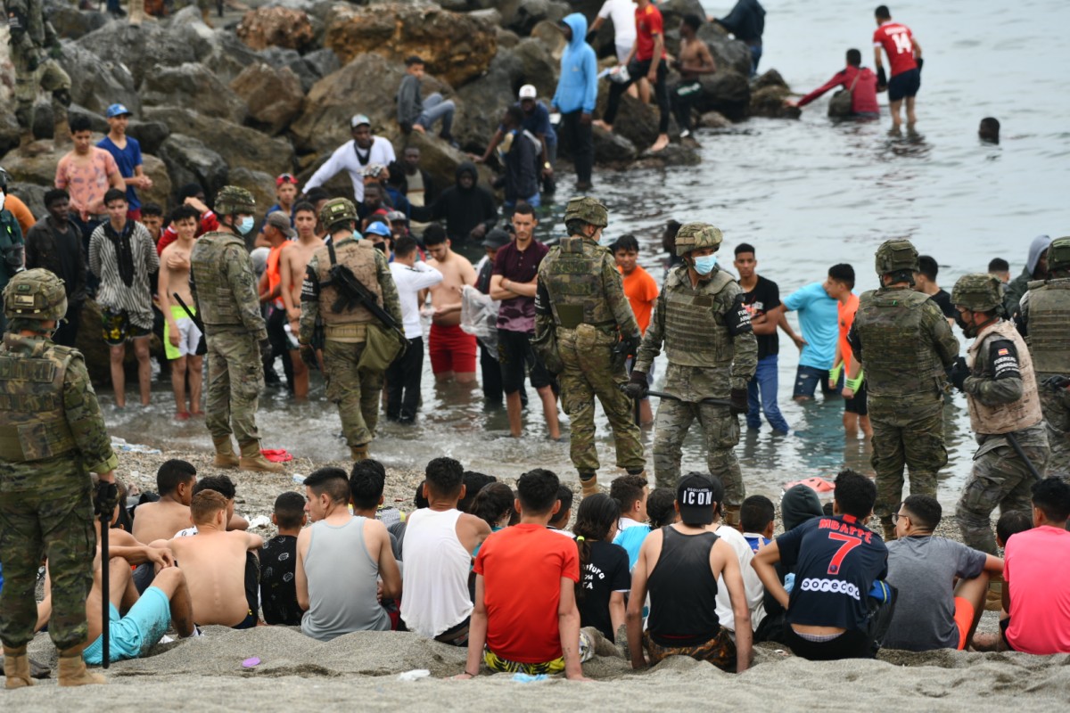 Soldats espanyols entre desenes de migrants a la costa de Ceuta.