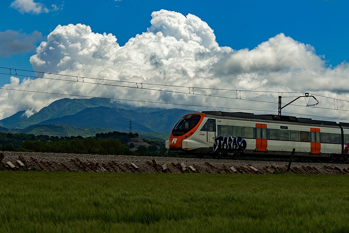 Un tren de la R3 al seu pas per Vic, amb el Montseny al darrere