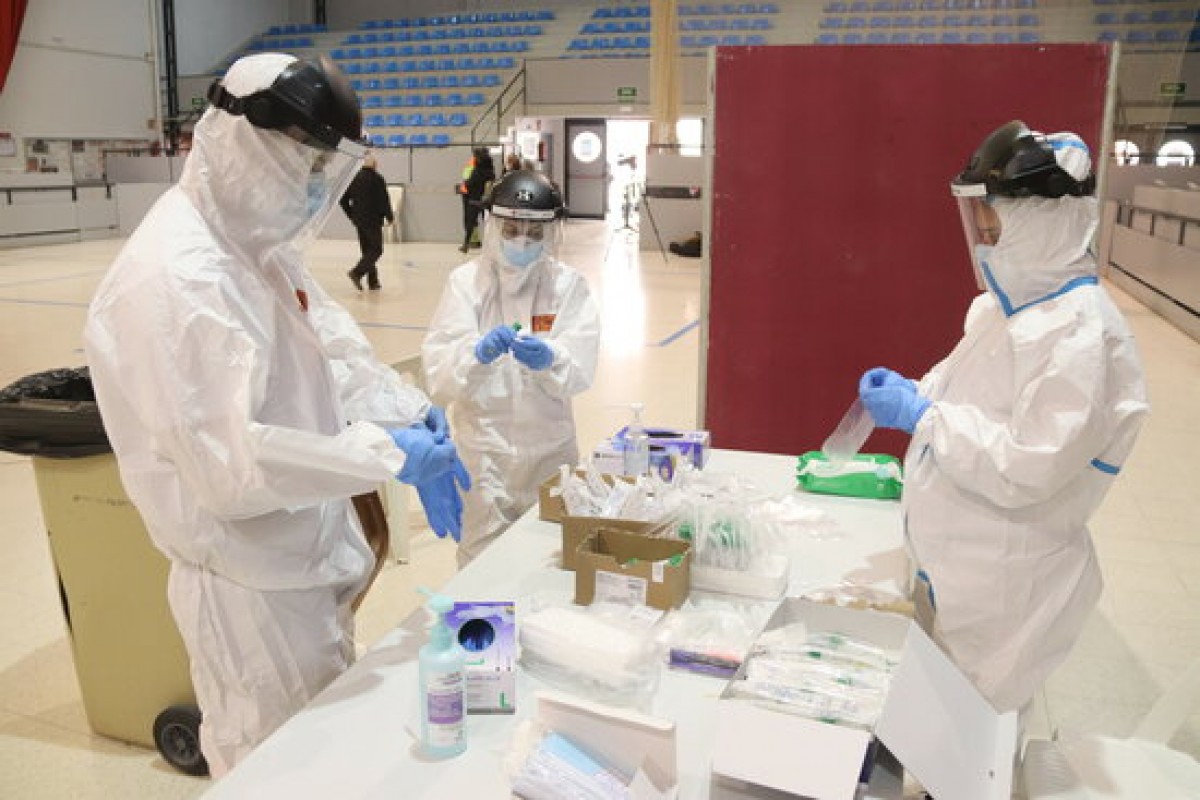 Tres sanitaris preparant el material per fer proves PCR