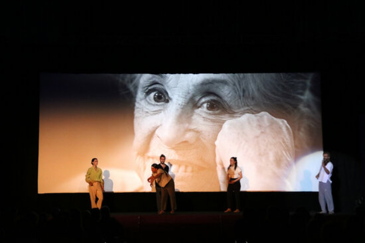 Ballarins actuant a l’escenari del FIC-CAT amb la imatge de Montserrat Carulla a la pantalla