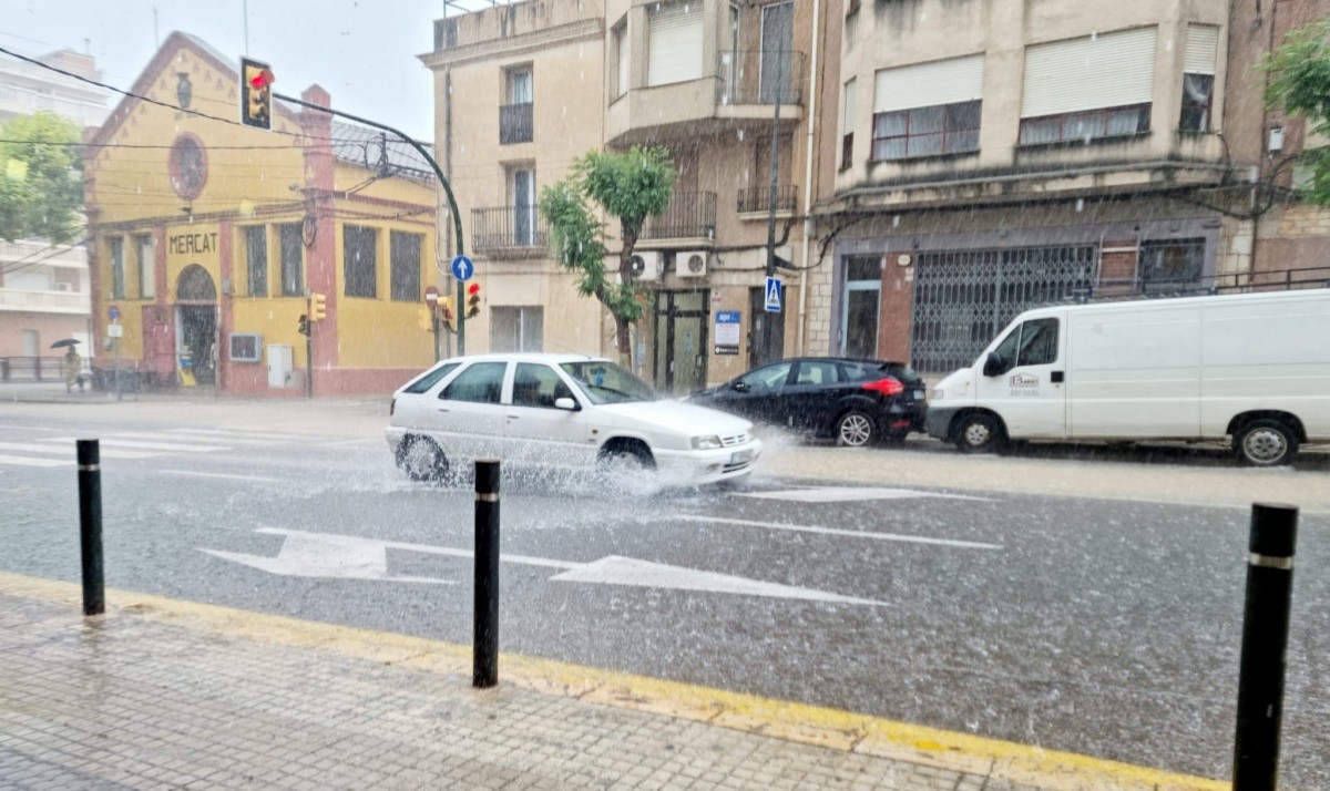 El carrer Major de Roquetes, amb l'aigua esborrant el límit entre la vorera i la carretera.