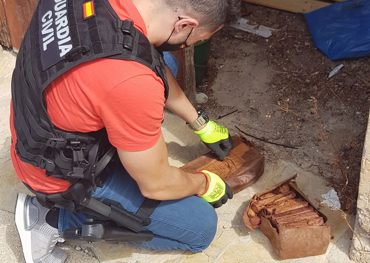 Pla d'un agent del GEDEX de la Guàrdia Civil revisant el material explosiu localitzat a Paüls. 
